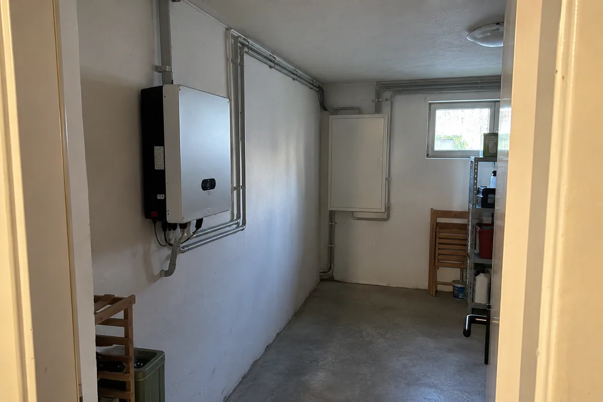 PV-Wechselrichter und geschlossener Verteilerschrank mit Kabelkanälen an verschiedenen Stellen eines Technikraums.
